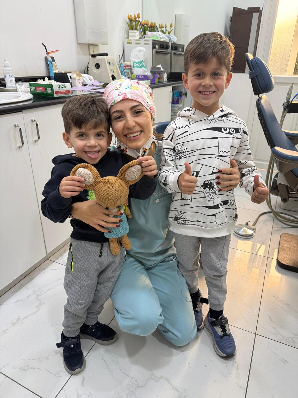 Dr. Marilyn Nohra with two young patients giving a thumbs-up at her pediatric dental clinic in Achrafieh, Beirut