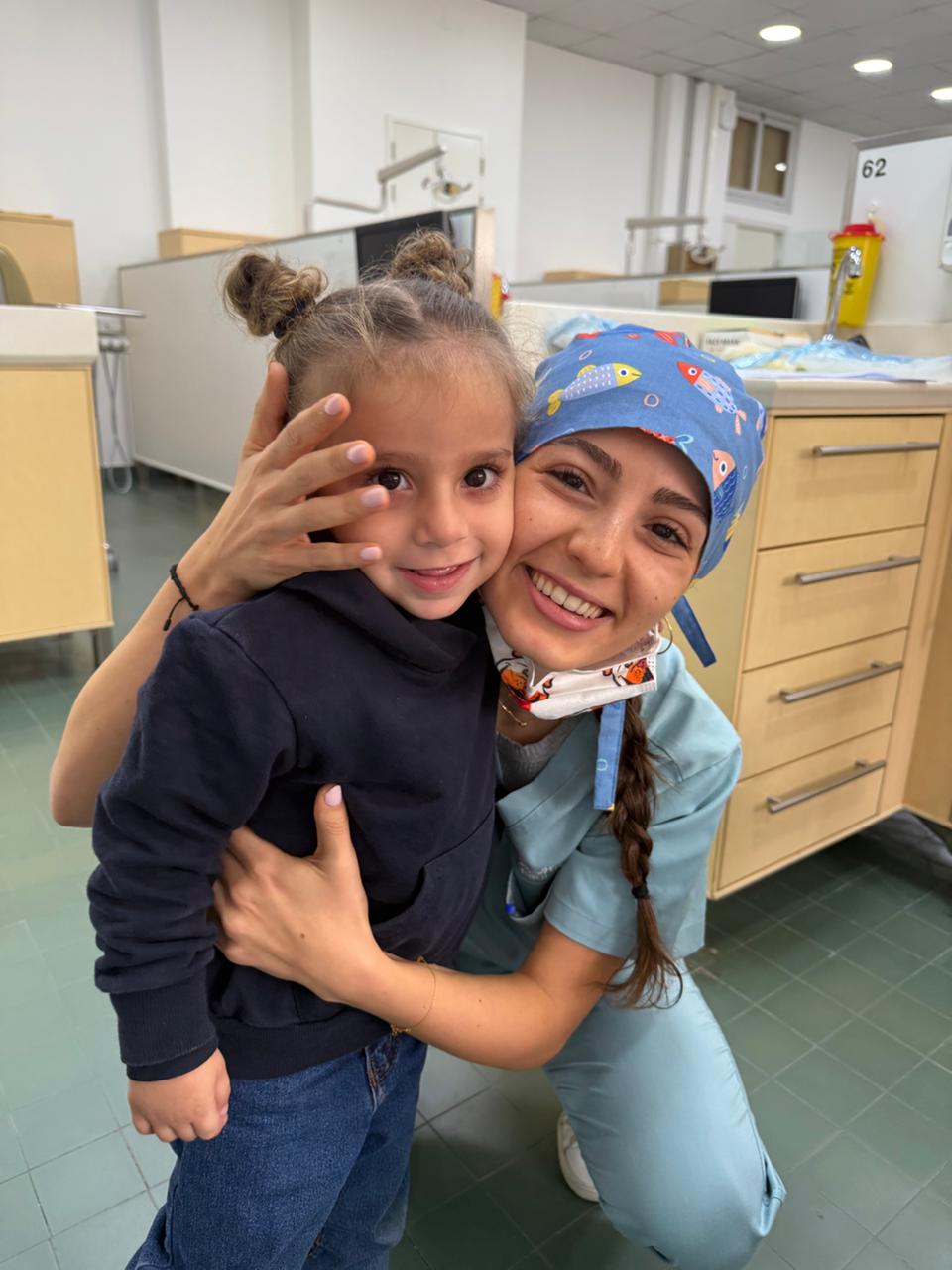 Dr. Marilyn Nohra holding a smiling young patient at Mario Nohra Dental Clinic, Achrafieh Syoufi, Beirut